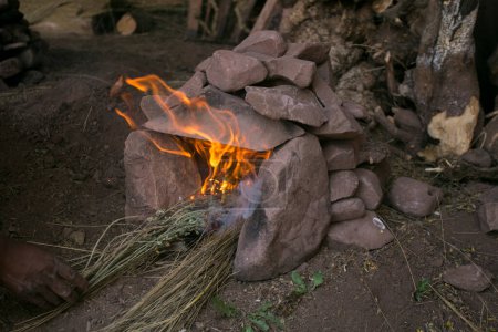 Téléchargez les photos : Pour préparer la cérémonie de Pachamanca, il faut d'abord préparer un four avec des pierres qui vont chauffer pendant 4 heures. Lorsque les pierres sont chaudes, la cuisson peut commencer. - en image libre de droit
