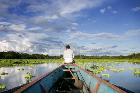 Téléchargez les photos : Pêcheur travaillant dans un lac de la jungle péruvienne. - en image libre de droit