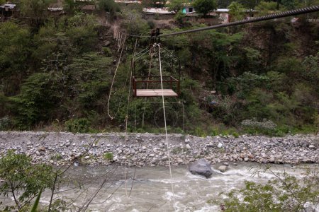 Foto de Oroya para transportar material o personas en un río en la selva peruana. Cesta suspendida de dos anillos, que corre a lo largo de una cuerda. - Imagen libre de derechos