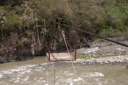 Photo for Oroya to transport material or people in a river in the Peruvian jungle. Basket suspended from two rings, which runs along a rope. - Royalty Free Image