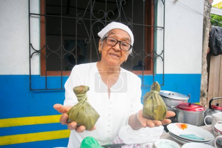 Téléchargez les photos : Yurimaguas, Pérou ; 1er octobre 2022 : Une femme vend des Juanes au marché de rue dans la jungle péruvienne. - en image libre de droit