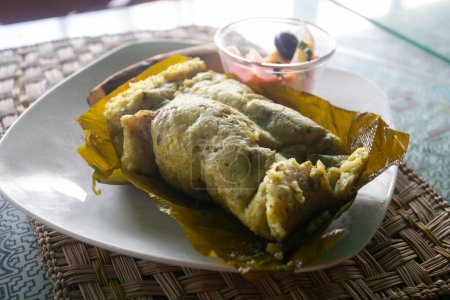 Foto de El Juane es un plato típico de la selva peruana. Se hace a partir de arroz, trozos de pollo; todo esto se envuelve en hoja de bijao y luego se hierve. - Imagen libre de derechos