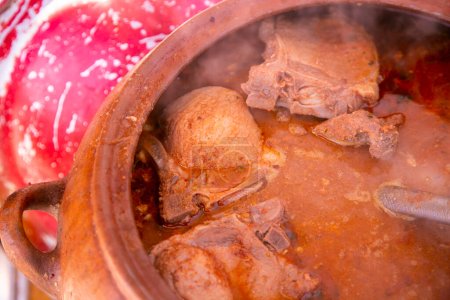 L'Adobo de Chancho arequipeo se compose d'un plat de viande de porc marinée qui est accompagné de légumes et d'assaisonnements cuits dans une marmite d'argile