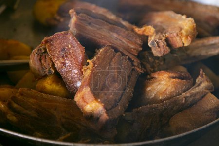 Foto de El chicharrn de cerdo es una comida tradicional en Perú. La grasa de cerdo se utiliza para cocinar la carne y consiste en freír la piel del cerdo con o sin carne. - Imagen libre de derechos