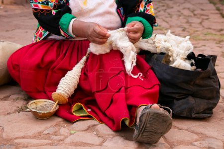 Photo for An indigenous woman from Lake Titicaca in Peru working with wool to make traditional cloth by hand. - Royalty Free Image