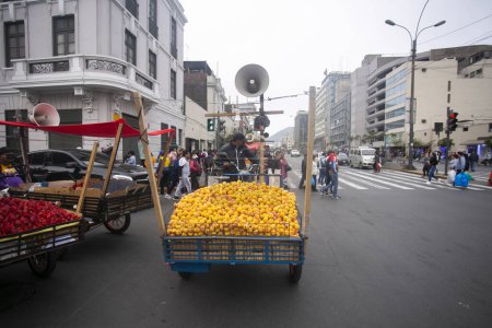 Téléchargez les photos : Lima, Pérou ; 1er janvier 2023 : Homme vendant des pêches dans les rues de la ville de Lima au Pérou. - en image libre de droit