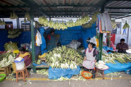Foto de Cusco, Perú; 1 de enero de 2023: Mujer vendiendo maíz en un puesto de mercado de alimentos en el mercado de San Pedro en Cusco. - Imagen libre de derechos