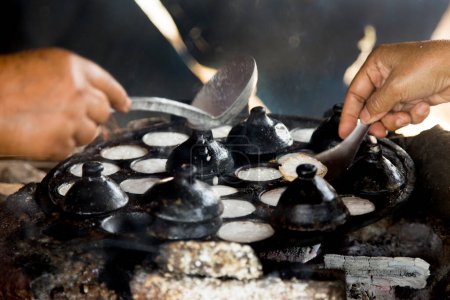 Téléchargez les photos : Femme préparant des desserts thaïlandais à la noix de coco. Kanom krok est un savoureux lait de coco thaïlandais mini crêpes populaire street food ainsi. - en image libre de droit