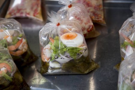 Téléchargez les photos : Nourriture dans des sacs en plastique dans un étal de nourriture de rue à Bangkok, Thaïlande. - en image libre de droit