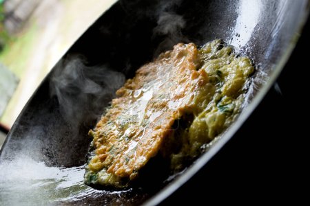 Téléchargez les photos : Omelette d'épinards cuite dans une poêle noire. - en image libre de droit