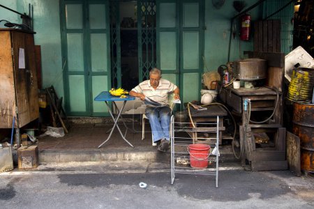 Photo for Bangkok, Thailand; 1st January 2023: Man reading the newspaper on the street. - Royalty Free Image