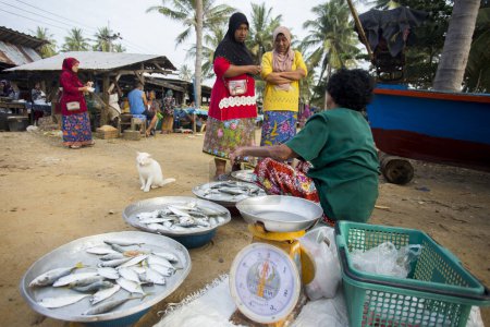 Téléchargez les photos : Sichon, Thaïlande ; 1er janvier 2023 : Vendeurs et acheteurs au marché aux poissons sur la plage de Sichon. - en image libre de droit