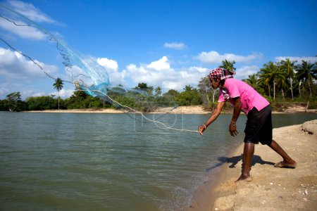 Foto de Sichon, Tailandia; 1 de enero de 2023: Pescador trabajando con una red de pesca en la playa de Sichon. - Imagen libre de derechos