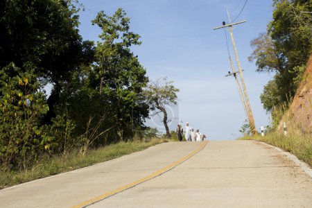 Photo for Koh Yao, Thailand; January 1, 2023: A group of Muslim religious walking along a road on an island in Thailand. - Royalty Free Image