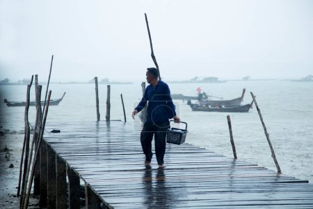 Foto de Koh Yao, Tailandia; 1 de enero de 2023: Un pescador regresa de un día de trabajo con pescado en un refrigerador. - Imagen libre de derechos