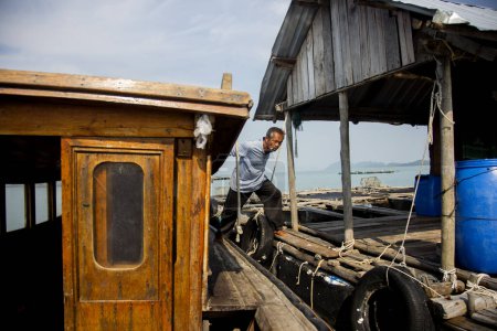 Téléchargez les photos : Koh Yao, Thaïlande ; 1er janvier 2023 : Pêcheur local dans une ferme de homard sur une île dans le sud de la Thaïlande. - en image libre de droit