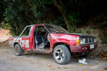 Téléchargez les photos : Koh Yao, Thaïlande ; 1er janvier 2023 : Vieille voiture abandonnée sans porte rouge. - en image libre de droit