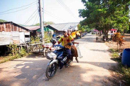 Foto de Koh Yao, Tailandia; 1 de enero de 2023: Dos pescadores que viajan en moto en el pueblo pesquero de Koh Yao. - Imagen libre de derechos