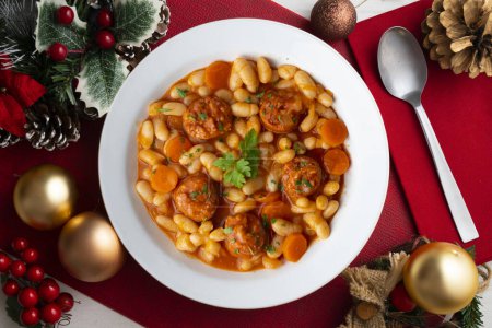 Photo for White bean stew with chorizo on a table decorated with Christmas elements. - Royalty Free Image