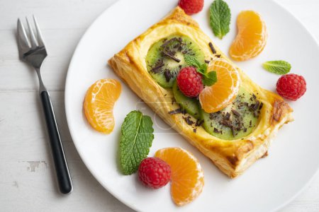Photo for Puff pastry tartlet with pastry cream and kiwi decorated with fresh fruit. - Royalty Free Image