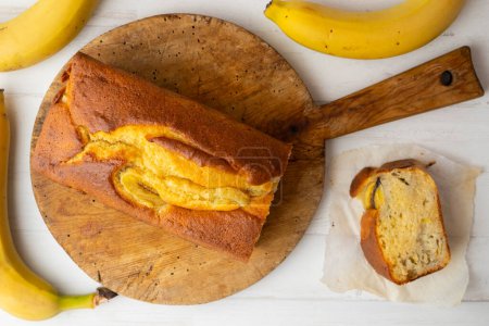 Foto de Pastel de plátano o pan de plátano hecho con un molde alargado y decorado con bayas rojas. - Imagen libre de derechos