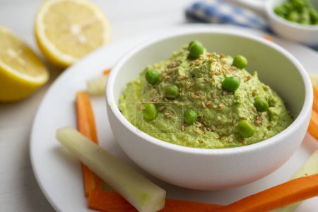 Téléchargez les photos : Hummus de pois vert servi avec carotte et concombre. - en image libre de droit