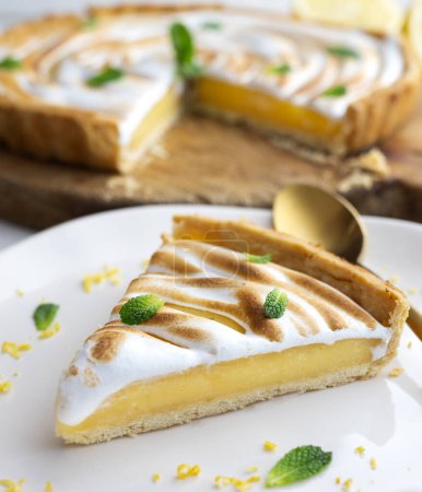 Téléchargez les photos : La tarte au citron est un gâteau composé d'une base de pâte feuilletée ou à croûte courte remplie de crème au citron. Ce gâteau est souvent complété par une meringue - en image libre de droit