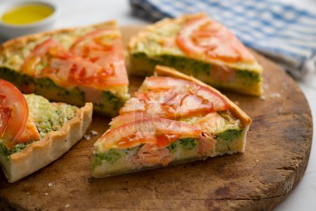 Foto de Quiche de estilo francés con brócoli, salmón y rodajas de tomate. - Imagen libre de derechos