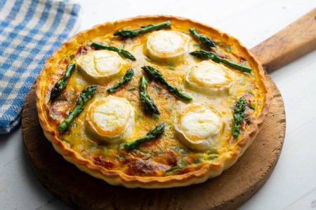 Photo for French style quiche with green asparagus, eggs, and slices of goat cheese. - Royalty Free Image