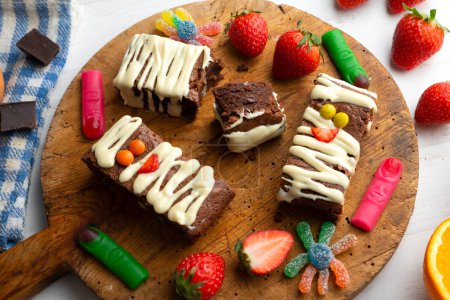 Téléchargez les photos : Brownie au chocolat décoré comme une momie d'Halloween. Décoré avec du chocolat blanc et des pépites de couleur. - en image libre de droit