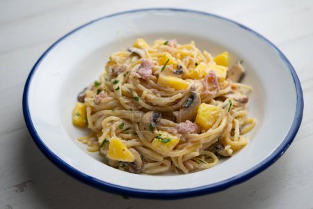 Photo for Spaghetti with carbonara sauce, ham and pineapple. - Royalty Free Image