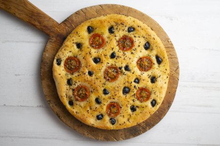 Téléchargez les photos : Foccaccia italienne aux olives noires et tomates cerises. - en image libre de droit