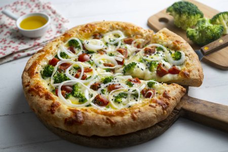 Foto de Pizza napolitana con queso, cebolla, brócoli y tomates cherry. - Imagen libre de derechos