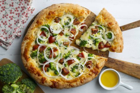 Foto de Pizza napolitana con queso, cebolla, brócoli y tomates cherry. - Imagen libre de derechos