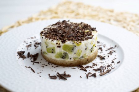 Téléchargez les photos : Gâteau au yaourt et kiwi avec une base de biscuits décorée de chocolat râpé. - en image libre de droit