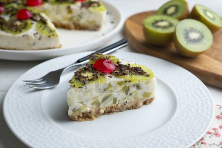 Téléchargez les photos : Gâteau au yaourt et kiwi avec une base de biscuits décorée de chocolat râpé. - en image libre de droit