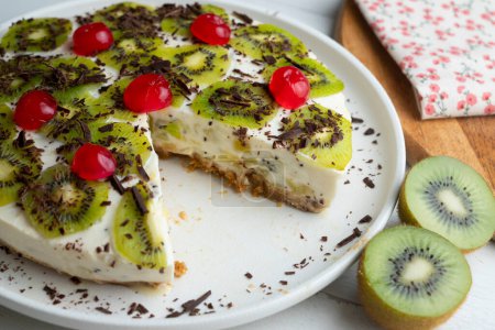 Photo for Yogurt and kiwi cake with a cookie base decorated with grated chocolate. - Royalty Free Image