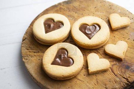 Photo for Butter cookies with hearts filled with chocolate cream and strawberries. - Royalty Free Image