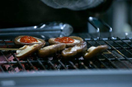 Téléchargez les photos : Champignons Shiitake japonais sauce tomate cuite sur un stand de street food à Tokyo. - en image libre de droit