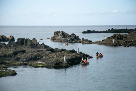 Téléchargez les photos : Shukunegi, Japon ; 1er octobre 2023 : Un groupe de touristes profitant d'une excursion en bateau Tarai Bune ou en baignoire le long de la côte d'Ogi - en image libre de droit