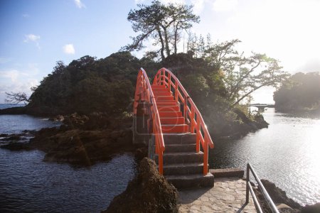 Téléchargez les photos : Pont rouge reliant les formations rocheuses volcaniques de l'île de Sado à Yajima et Kyojima. - en image libre de droit