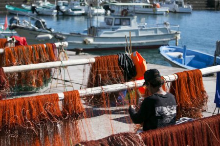 Photo for Nachikatsuura, Japan; 1st October 2023: Fishermen mending their fishing nets at Katsuura Harbor in Wakayama. - Royalty Free Image