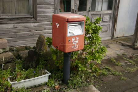 Foto de Ogi, Japón; 1 de octubre de 2023: Buzón rojo japonés en una calle de la ciudad de Oji en la isla de Sado. - Imagen libre de derechos