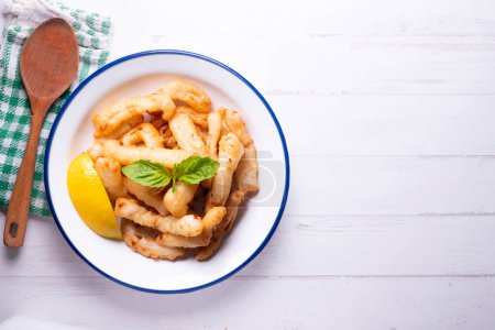 Photo for Traditional spanish tapa. Rabas, tasty fried squid with lemon. - Royalty Free Image