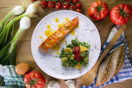 Photo for Grilled salmon with orange sauce and a salad. Typical Mediterranean coast dish. - Royalty Free Image
