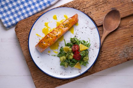 Photo for Grilled salmon with orange sauce and a salad. Typical Mediterranean coast dish. - Royalty Free Image