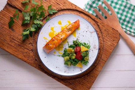 Téléchargez les photos : Saumon grillé avec sauce orange et salade. Plat typique de la côte méditerranéenne. - en image libre de droit