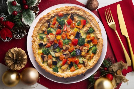 Photo for Veggie quiche traditional french recipe on puff pastry. Christmas food served on a table decorated with Christmas motifs. - Royalty Free Image