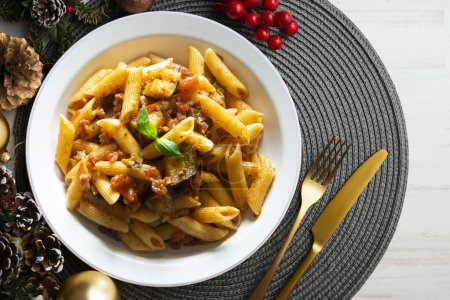 Pasta alla norma traditional italian recipe. Dish served on a table with christmas decoration.