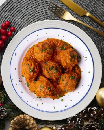 Photo for Meat meatballs with tomato sauce and vegetables. Christmas food on a table with decorations. - Royalty Free Image
